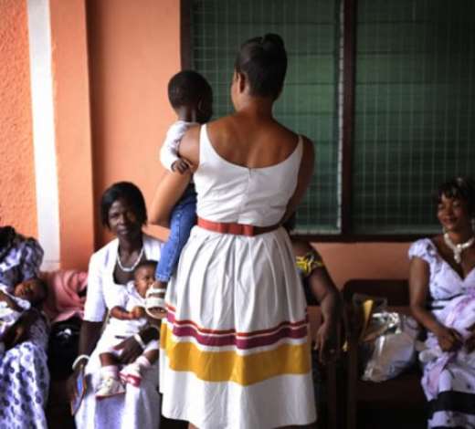 Michelle Obama holds a child while watching a maternal health session at the hospitalPhotograph: Shawn Thew/EPA
