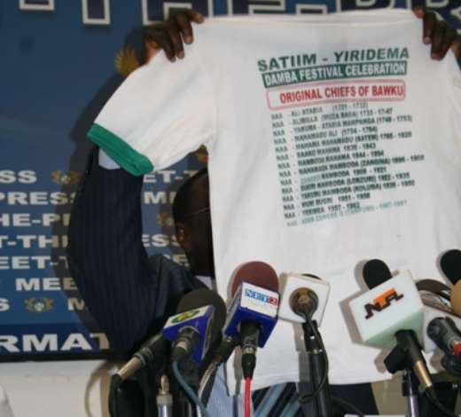 Mr John Tia Akologu, Minister of Information showing a T-shirt which concerns Bawku to the media.
