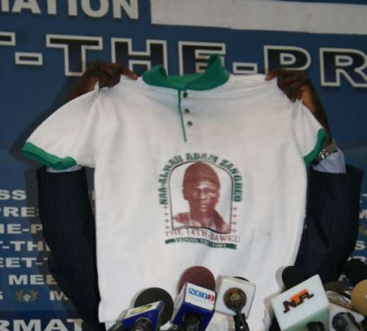 Mr John Tia Akologu, Minister of Information showing a T-shirt which concerns Bawku to the media.