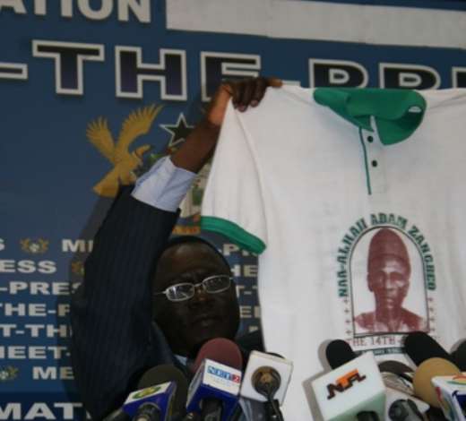 Mr John Tia Akologu, Minister of Information showing a T-shirt which concerns Bawku to the media.