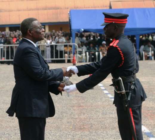 PRESIDENT MILLS PRESENTS THE SWORD TO THE BEST CADET OFFICE FOR COURSE 42 CADET OFFICER JOHN ATANGA