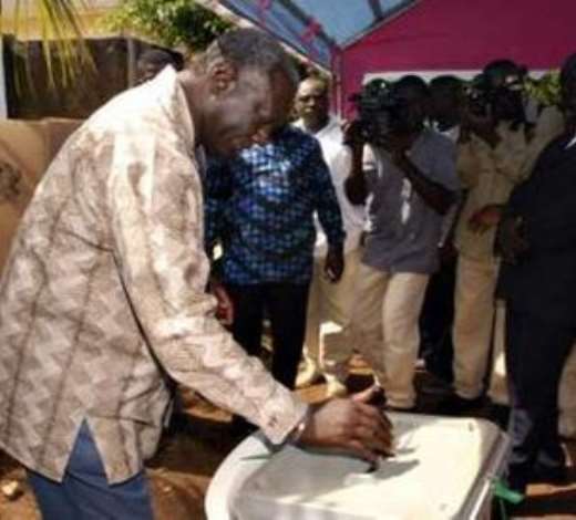 President John Kufuor casts his ballot in the capital Accra