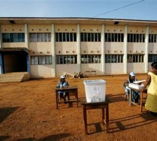 Rosemond Anim, right, is handed a presidential ballot by a poll worker before voting at Accra Girls Secondary School in Accra, Ghana, Sunday, Dec. 7, 2008. An estimated 12.4 million registered voters, roughly half the country s population of 23 million, will choose from one of eight candidates to succeed President John Kufuor, who is stepping down after two terms as required by law. (AP Photo/Rebecca Blackwell)
