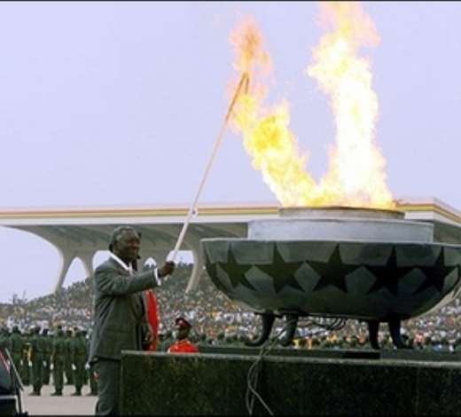 Ghanas president John Kufuor lights a flame symbolizing the spirit of independence at a ceremony in the packed Independence Square in Accra. Ghanaians turned out in their thousands Tuesday for colourful ceremonies marking independence from Britain 50 years ago when the country became the first black African state to break the bonds of colonial rule.(AFP/Kambou Sia)