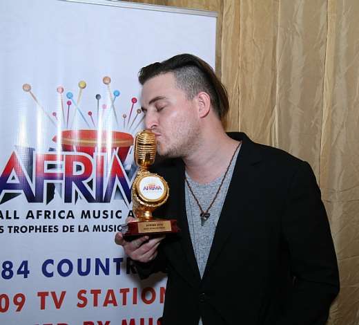 Dear Zim from Zimbabwe winner of the Best African Rock award kissing his trophy at the AFRIMA award held recently at the oriental Hotel, Victoria Island, Lagos, Nigeria