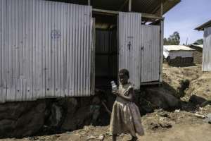 A child walks past the toilets at the Kigonze displacement camp.  By Glody MURHABAZI (AFP)