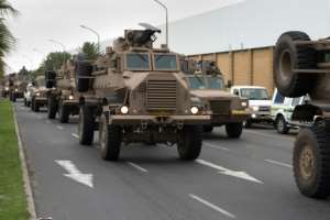 A convoy of South African army vehicles drives through a street in Cape Town as part of the deployment.  By RODGER BOSCH (AFP)