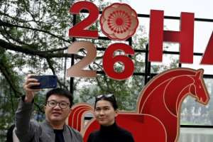 A couple takes a selfie next to a New Years banner in Hanoi.  By Nhac NGUYEN (AFP)
