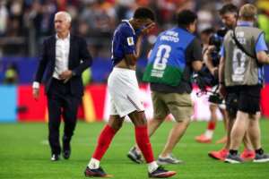 A devastated Kylian Mbappe trudges off as coach Didier Deschamps looks on after France were defeated by Spain.  By FRANCK FIFE (AFP)