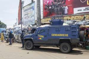 A gendarme stands guard next to an armoured vehicle in Conakry ahead of Guineas constitutional referendum.  By PATRICK MEINHARDT (AFP)