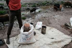 A man sells sorghum on the street from an old USAID bag in Maban, South Sudan, in August 2025. By GUY PETERSON (AFP/File)