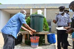 A man washes his hands at the entrance to Abidjans main prison.  By ISSOUF SANOGO (AFP)