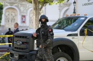 A member of the Tunisian security forces stands guard at the site of a suicide attack in the Tunisian capital Tunis.  By FETHI BELAID (AFP)