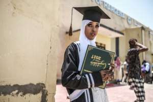 A new graduate stands outside the University of Hargeisa proudly holding her degree certificate.  By EDUARDO SOTERAS (AFP)