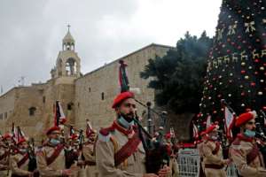A Palestinian band parades in front of the Church of the Nativity in Bethlehem on December 24.  By HAZEM BADER (AFP)