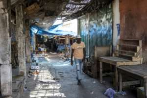A pedestrian walks along a deserted market in Bissau on November 27, 2025, one day after a military coup.  By PATRICK MEINHARDT (AFP)