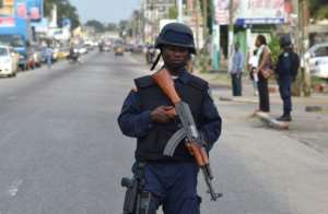 A policeman on patrol keeps watch near the headquarters of the National Electoral Commission in Monrovia while partial first-round results are announced