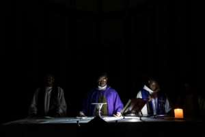 A priest prays during a service at the Ponta Gea Roman Catholic Cathedral.  By WIKUS DE WET (AFP)