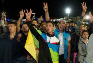 A protester carries the Berber flag as protesters shout slogans in Al Hoceima, Morocco on October 30, 2016, following the death of fishmonger Mouhcine Fikri, who was crushed to death on October 28 in a rubbish truck