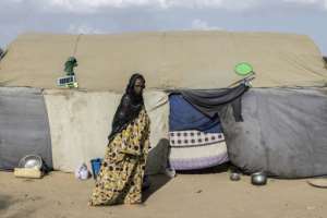 A refugee walks past a tent at a makeshift camp in Doueinkara, near the Mauritanian border with Mali.  By PATRICK MEINHARDT (AFP)