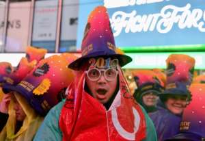 A reveler smiles under the rain as people gather for the New Years Eve celebration in Times Square in New York.  By Angela Weiss (AFP)
