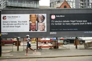A runner passes posters critical of comments made about migrants in Manchester, north-west England.  By Oli SCARFF (AFP)