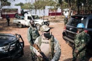 A Rwandan peacekeeper, right, a private Russian security guard, centre, and a member of the presidential guard, left, provided protection when Touadera cast his vote at a school in Bangui last month.  By ALEXIS HUGUET (AFP)