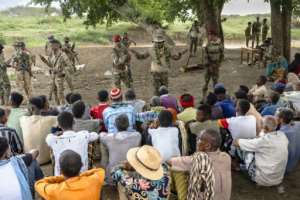 A Somalia National Army officer talks to villagers in the recently recaptured town of Bariirein November 2025.  By Tony KARUMBA (AFP)