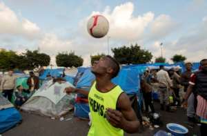 A sub-Saharan migrant practices his skills at a make-shift football pitch in the Oulad Ziane migrant camp in Moroccos Casablanca on February 19, 2018