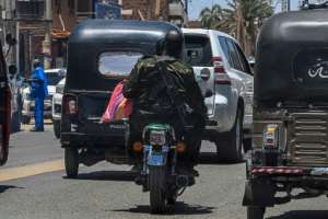 A Sudanese army soldier carries Kalashnikov while riding a motorcycle along the street in Khartoum in April.  By Khaled DESOUKI (AFP)