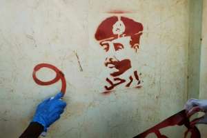 A Sudanese protester writes leave in Arabic next to a painting of General Abdel Fattah al-Burhan, amid ongoing demonstrations against a military coup.  By - (AFP)