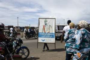 A supporter carries a poster of Guinea President Mamady Doumbouya at a rally in Conakry.  By PATRICK MEINHARDT (AFP)