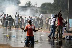 A supporter of Gabonese opposition leader Jean Ping prays in front of security forces blocking a demonstration trying to reach the electoral commission in Libreville