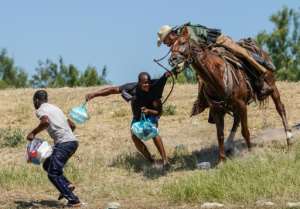 A US Border Patrol agent on horseback tries to stop Haitian migrants on the Mexican border at Del Rio, Texas in 2021.  By PAUL RATJE (AFP)