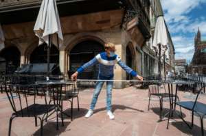 A waiter measures the distance between tables at a Strasbourg restaurant, as France eases its virus measures.  By PATRICK HERTZOG (AFP)