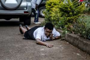 A woman hides behind a car during the deadly Nairobi hotel attack.  By Luis TATO, Luis TATO (AFP)
