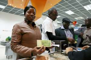 A woman holds a two dollar note that she received as change in a shop in Harare on November 28, 2016