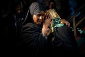 A woman is reunited with family after being evacuated from the DusitD2 compound in Nairobi.  By Fredrik Lerneryd (AFP)