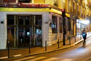 A woman walks by a closed restaurant in France during a second lockdown.  By JOEL SAGET (AFP)