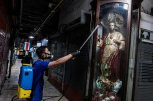 A worker disinfects the central market in San Jose, Costa Rica.  By Ezequiel BECERRA (AFP)