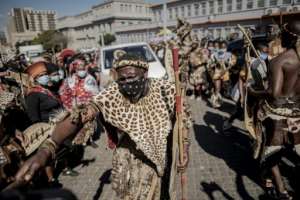 A Zulu mourner, clad in traditional leopardskin, cleared the way for the hearse in front of the morgue.  By Luca Sola (AFP)
