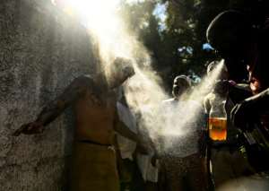 Abakua priest Ivanieski Quintana (right) cleanses Yosleny Luna in an oath ceremony.  By Yamil LAGE (AFP)