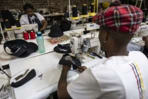 About 10 tailors sew away behind large windows under the high ceiling of the workshop.  By OLYMPIA DE MAISMONT (AFP)