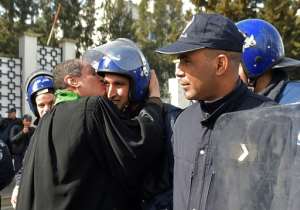 An Algerian lawyer kisses a policeman during a protest against ailing president's bid for a fifth term in power, in Algiers on March 7, 2019. By RYAD KRAMDI (AFP)