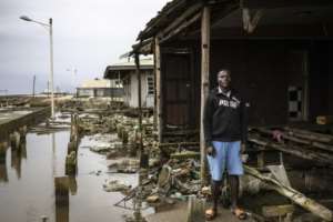 Augustin Edward, 30, carpenter, stands outside his destroyed home.  By OLYMPIA DE MAISMONT (AFP)