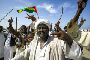 Beja people raise the flag of the Beja Congress political group as they demonstrate outside the Osman Digna port.  By ASHRAF SHAZLY (AFP/File)