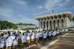 Children cheer as Pope Leo XIVs motorcade arrives at the Cameroonian presidential palace.  By Alberto PIZZOLI (AFP)