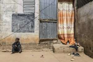 Coumba, who lost her father to a pirogue accident in 2022, sits outside her home in Mbour, Senegal.  By PATRICK MEINHARDT (AFP)