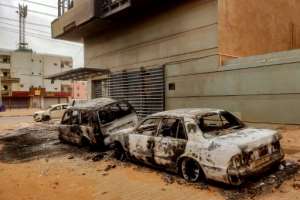 Destroyed vehicles are pictured outside the burnt down headquarters of Sudans Central Bureau of Statistics in the south of Khartoum on May 29, 2023.  By - (AFP)
