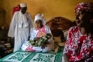 Diao admires his great-grandson Mohamed, born just two days before his return to Senegal.  By CARMEN ABD ALI (AFP)